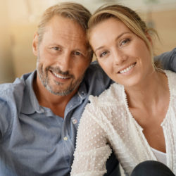 Mature couple relaxing at home, looking at camera